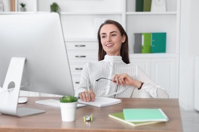 Smiling businesswoman working at table in office