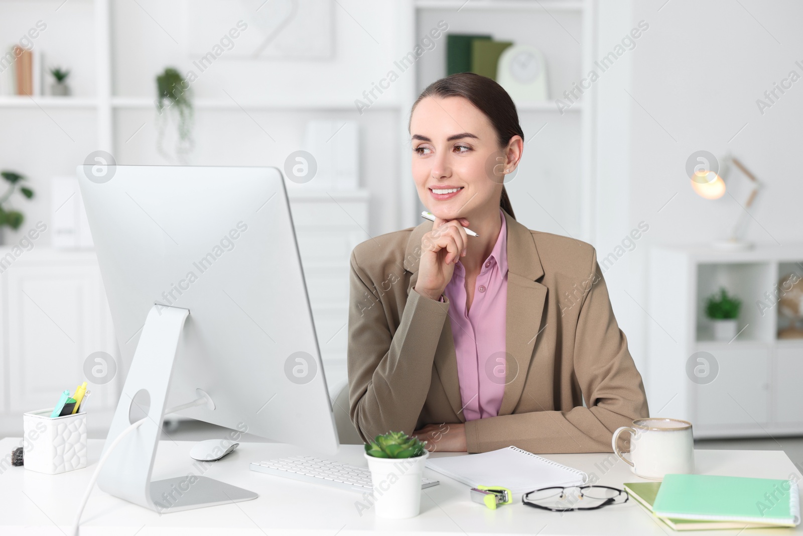 Photo of Smiling businesswoman working at table in office