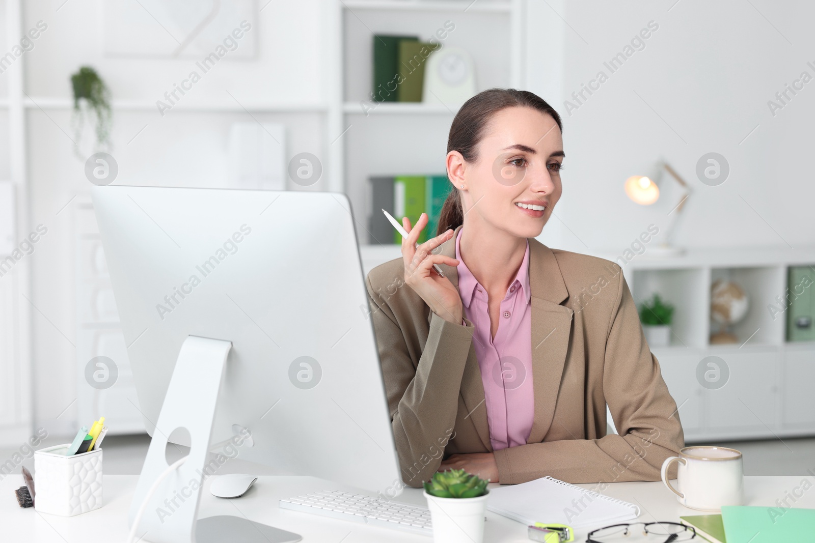 Photo of Smiling businesswoman working at table in office