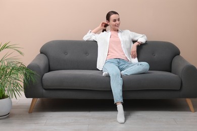 Smiling woman relaxing on sofa at home