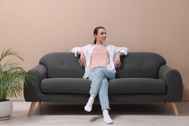 Photo of Smiling woman relaxing on sofa at home