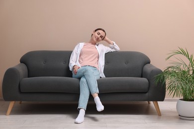 Smiling woman relaxing on sofa at home