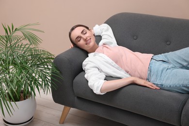 Photo of Smiling woman relaxing on sofa at home