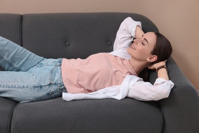 Smiling woman relaxing on sofa at home