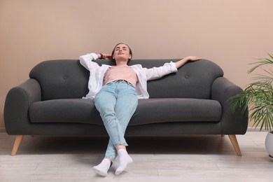 Photo of Beautiful woman relaxing on sofa at home