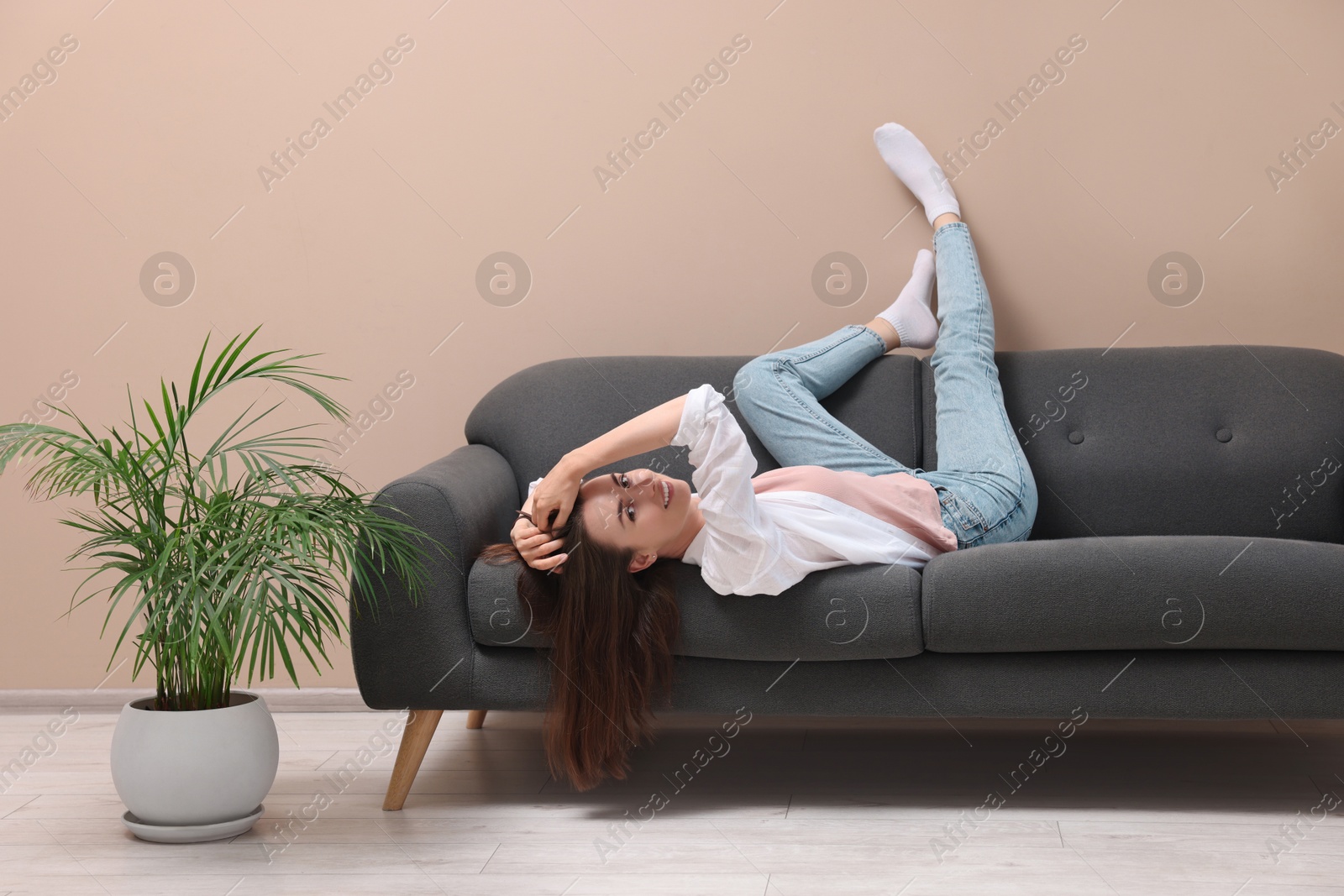 Photo of Smiling woman posing on sofa at home