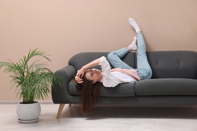 Smiling woman posing on sofa at home