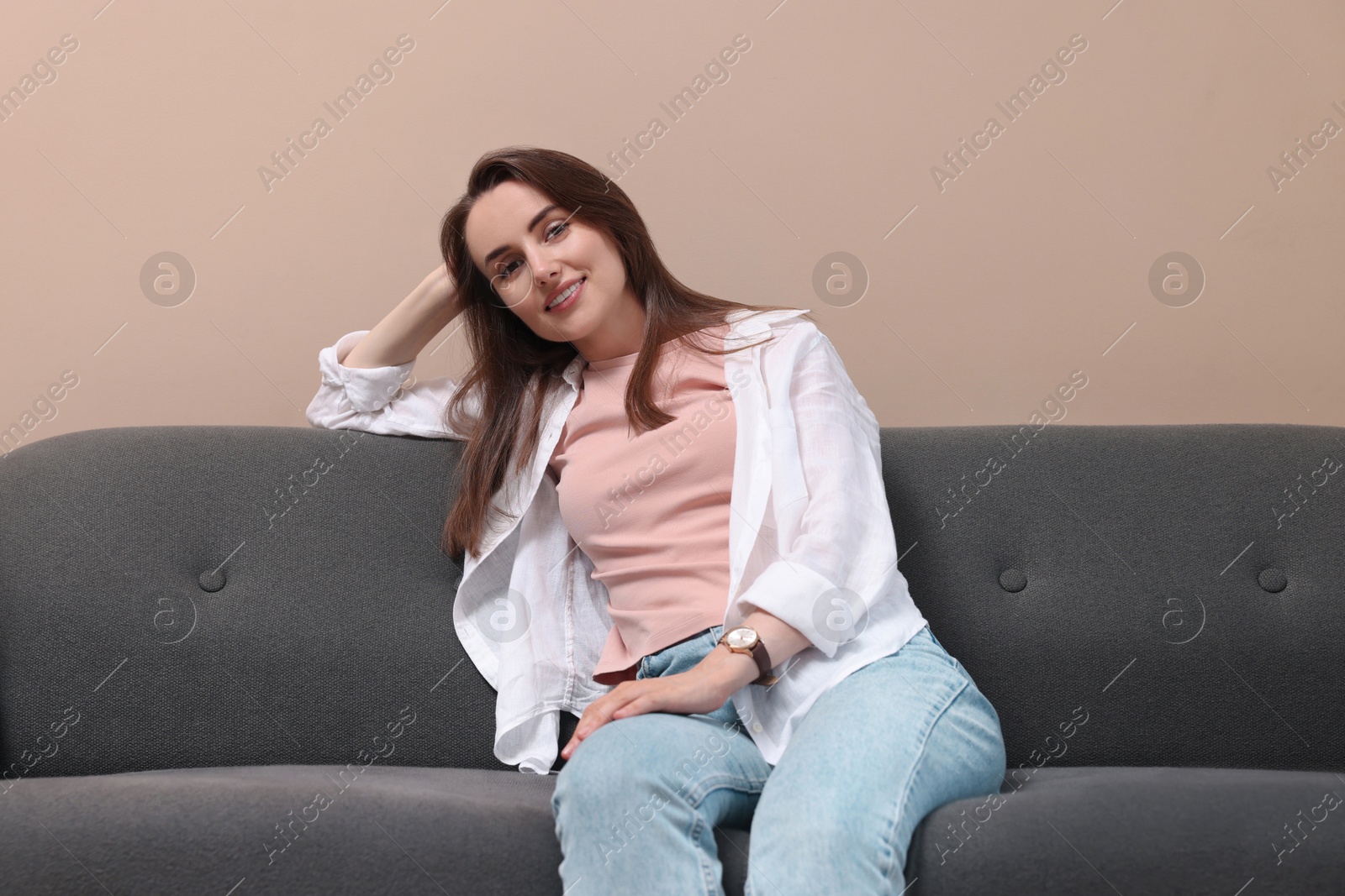 Photo of Smiling woman relaxing on sofa at home