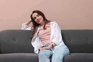 Smiling woman relaxing on sofa at home