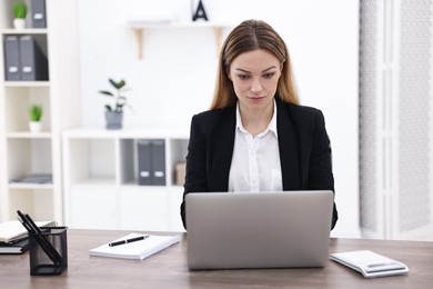 Photo of Banker using laptop at wooden table in office