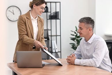 Photo of Banker working with client at table in office