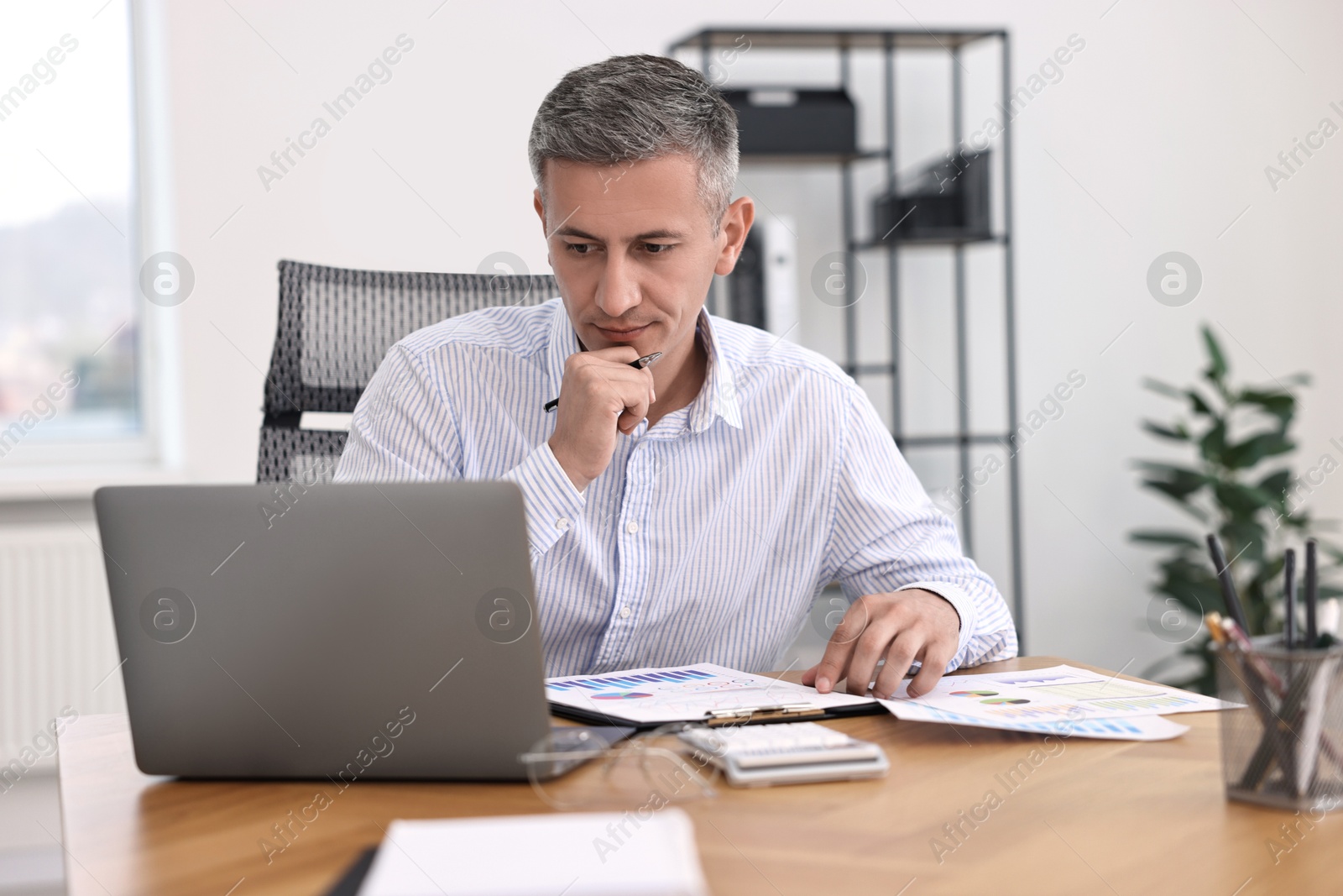 Photo of Banker working at wooden table in office