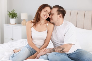 Happy couple spending time together on bed at home