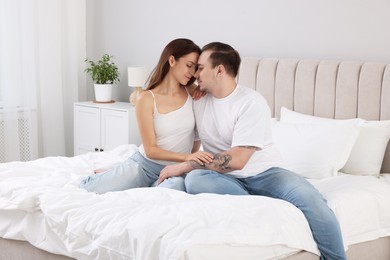 Cute couple spending time together on bed at home