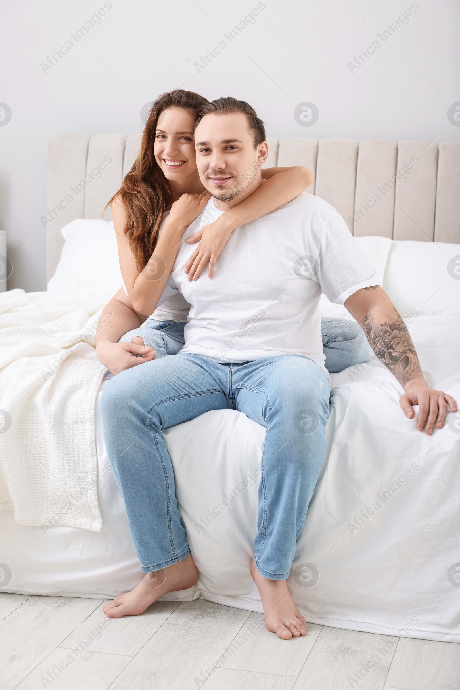 Photo of Happy couple spending time together on bed at home