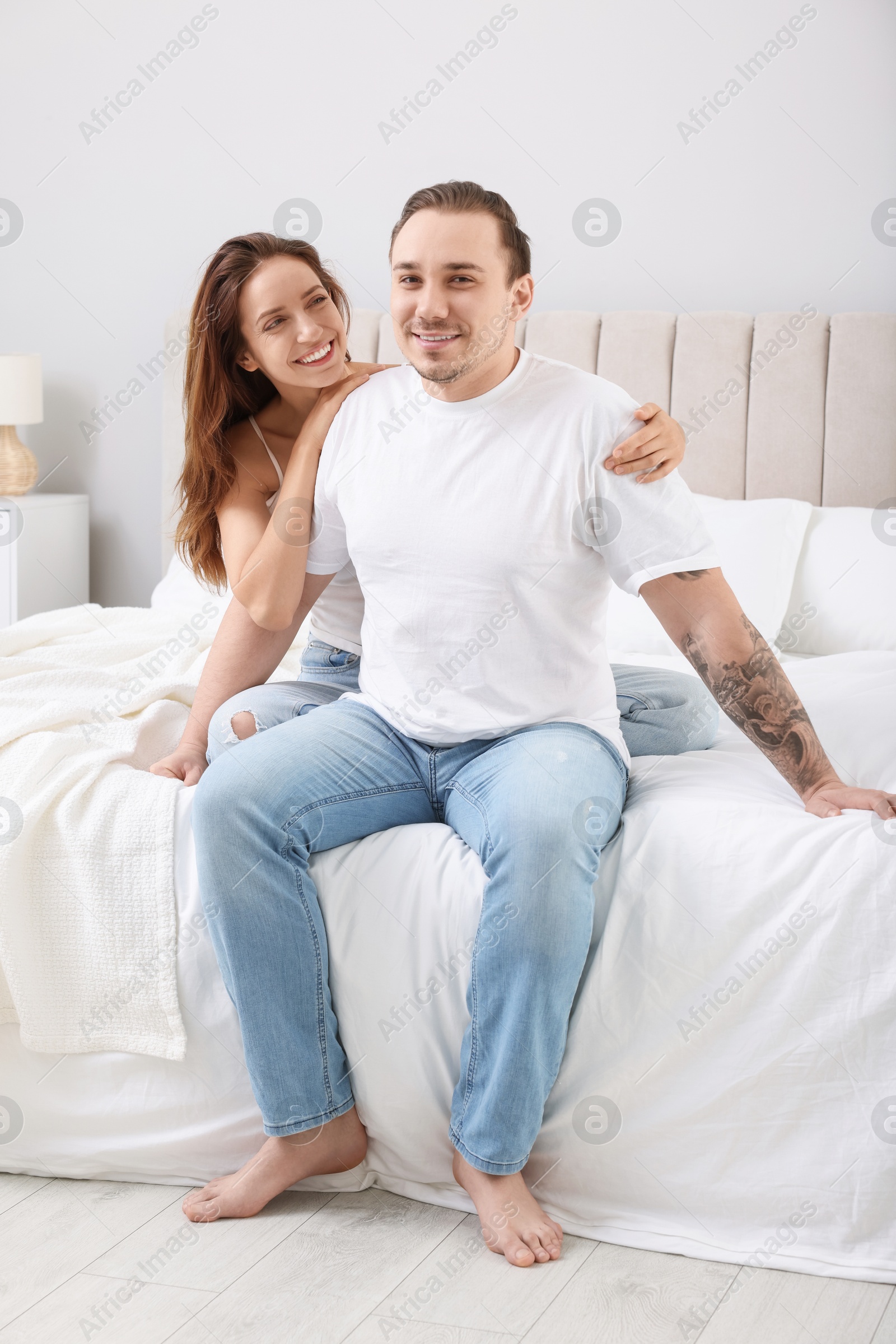 Photo of Happy couple spending time together on bed at home