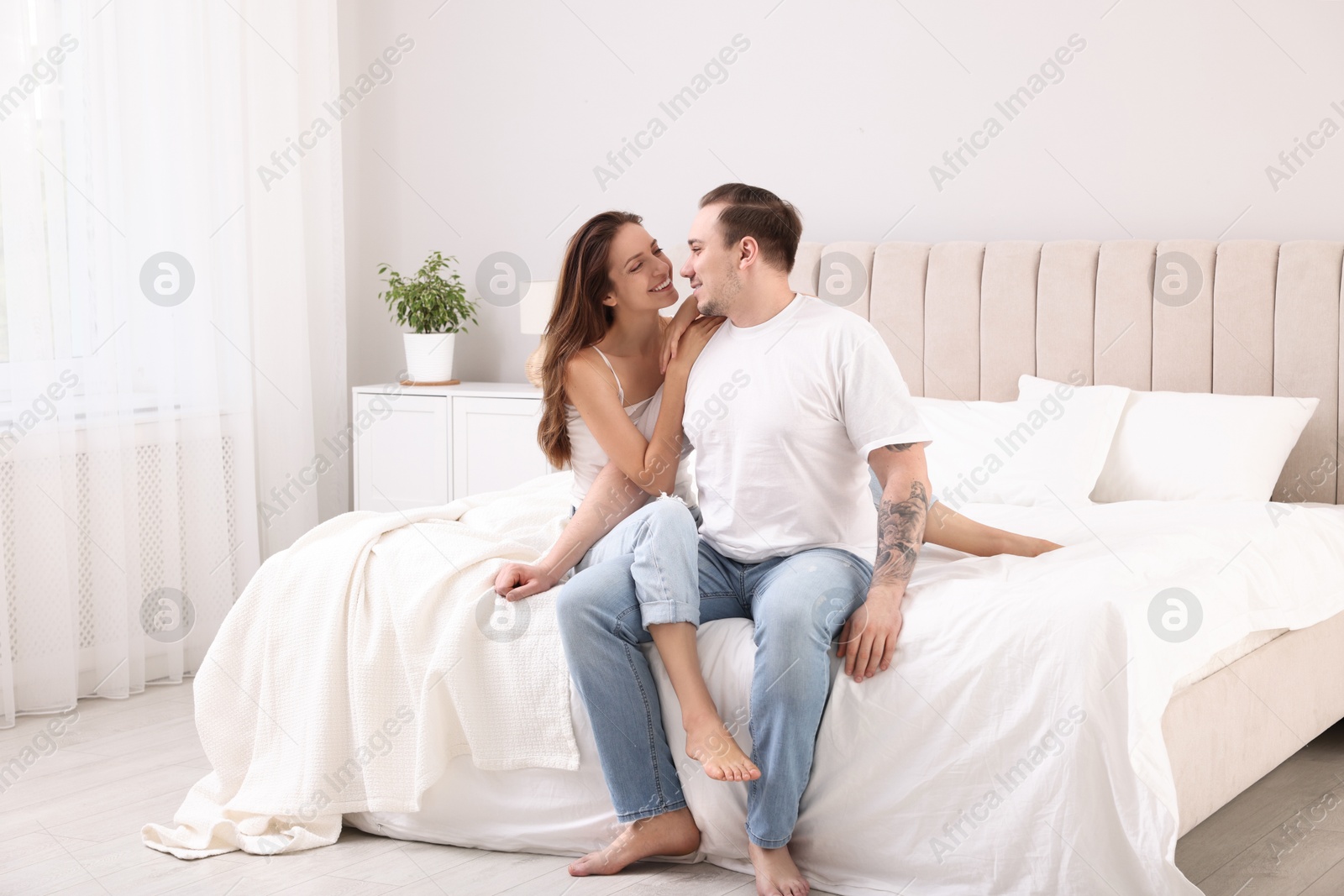 Photo of Happy couple spending time together on bed at home