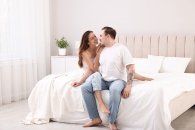 Happy couple spending time together on bed at home