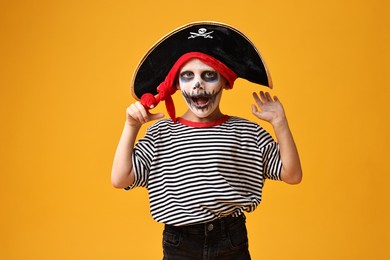 Photo of Funny boy dressed like pirate on yellow background. Halloween costume