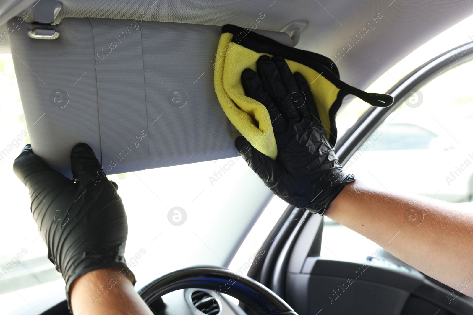 Photo of Man cleaning car interior with rag, closeup