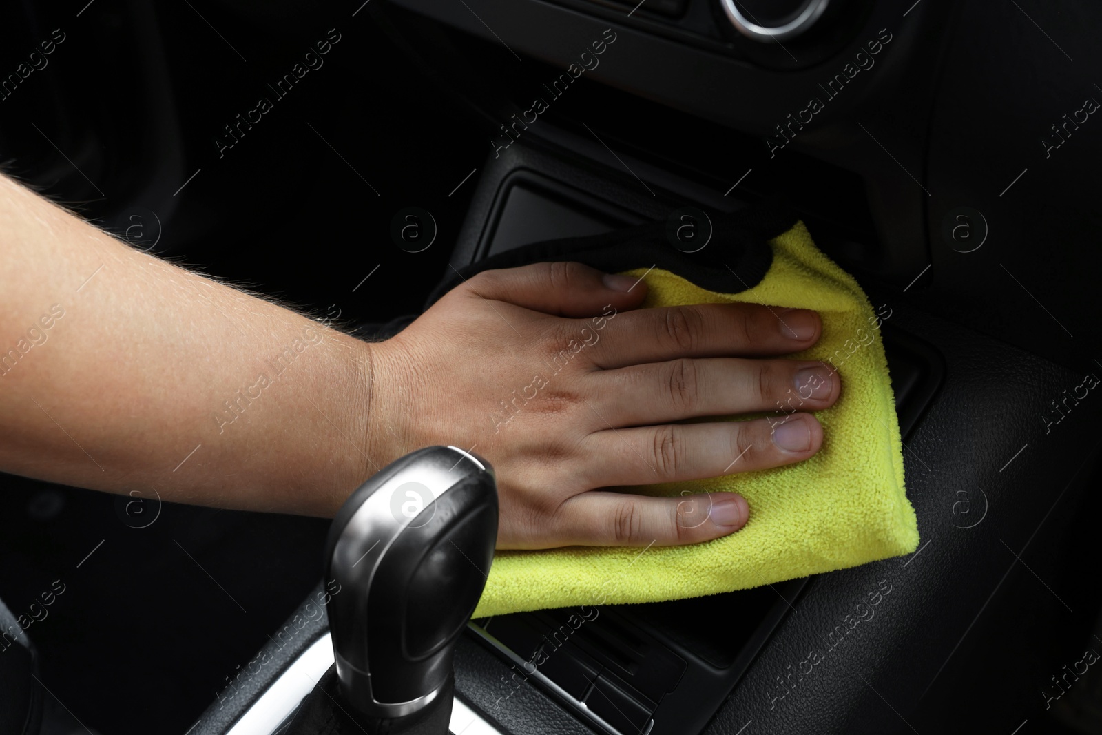 Photo of Man cleaning car interior with rag, closeup