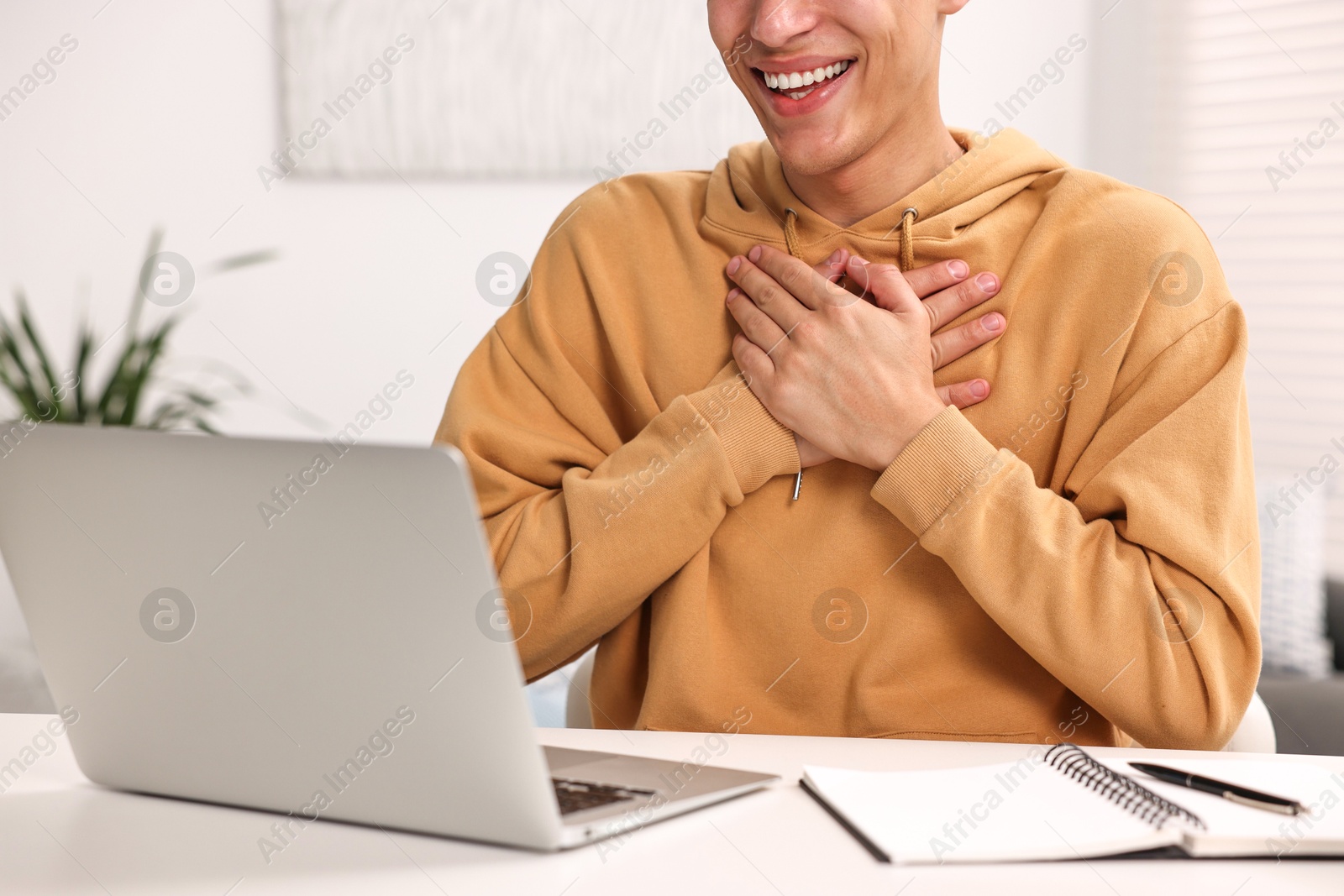 Photo of Young man using sign language during video call indoors, closeup