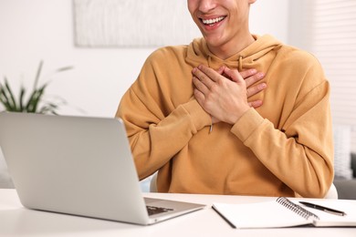 Young man using sign language during video call indoors, closeup