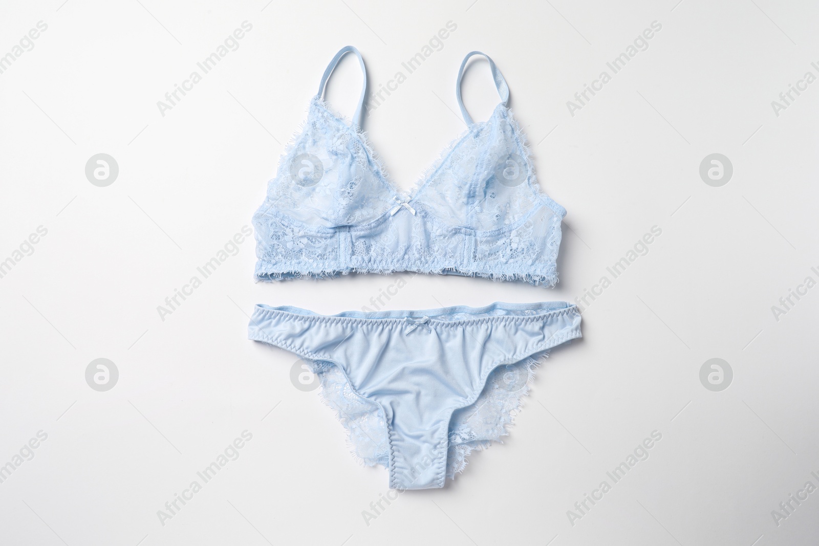 Photo of Elegant light blue lace women's underwear on white background, top view