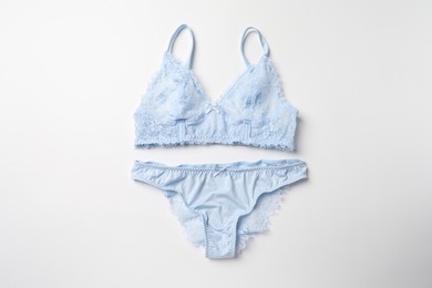 Photo of Elegant light blue lace women's underwear on white background, top view