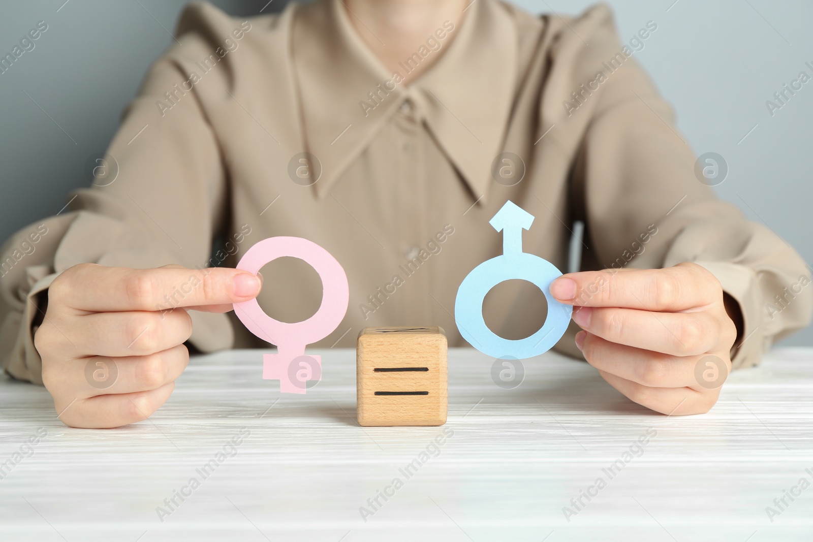 Photo of Gender equality concept. Woman with male and female symbols at white table, closeup