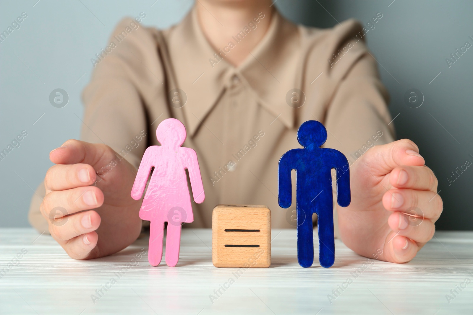 Photo of Gender equality concept. Woman with male and female figures at white table, closeup