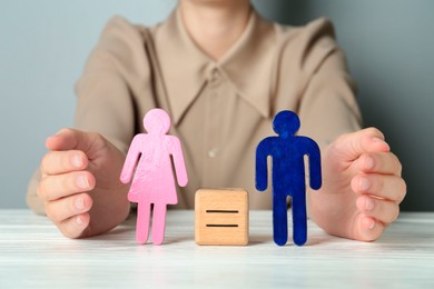 Photo of Gender equality concept. Woman with male and female figures at white table, closeup