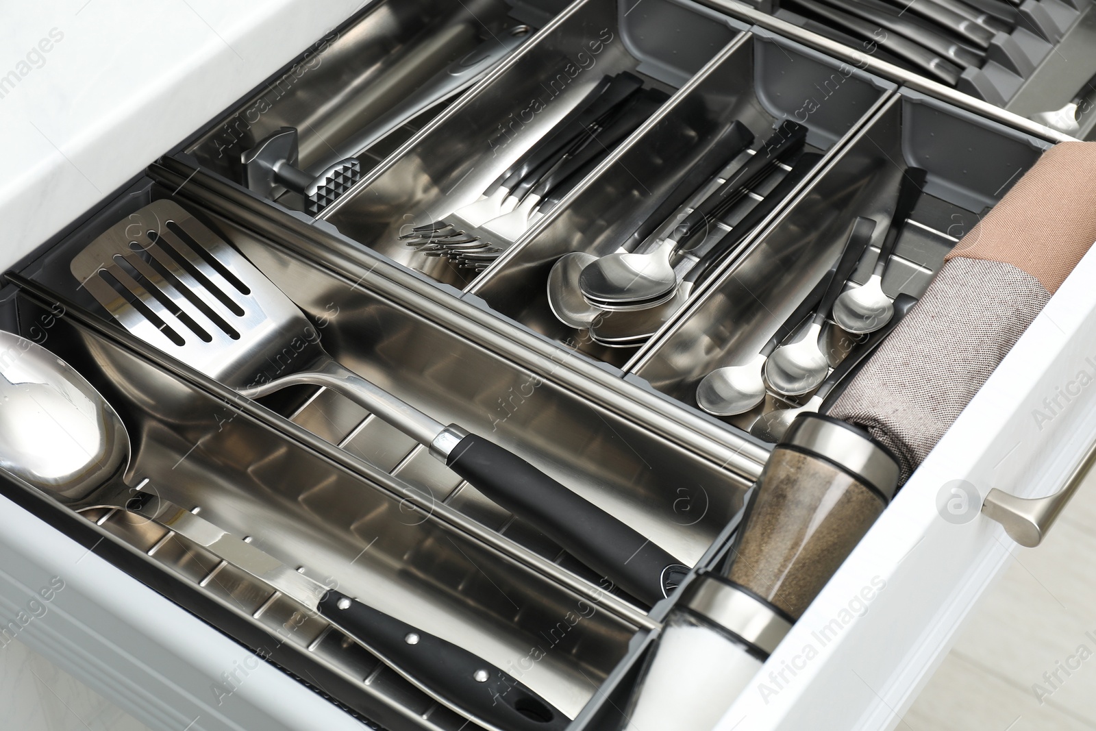 Photo of Box with cutlery in drawer, closeup. Kitchen utensils storage