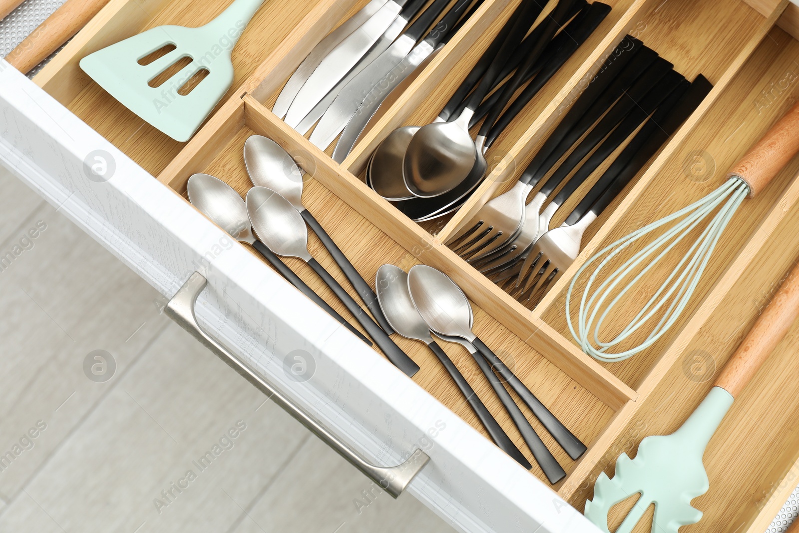 Photo of Box with cutlery in drawer, closeup. Kitchen utensils storage