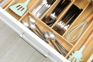 Photo of Box with cutlery in drawer, closeup. Kitchen utensils storage