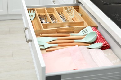 Photo of Box with cutlery in drawer, closeup. Kitchen utensils storage