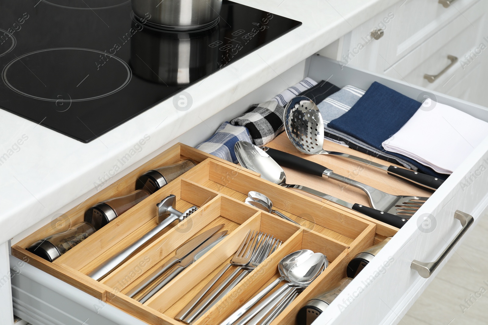 Photo of Box with cutlery in drawer, closeup. Kitchen utensils storage