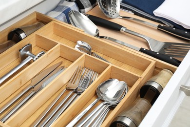 Photo of Box with cutlery in drawer, closeup. Kitchen utensils storage