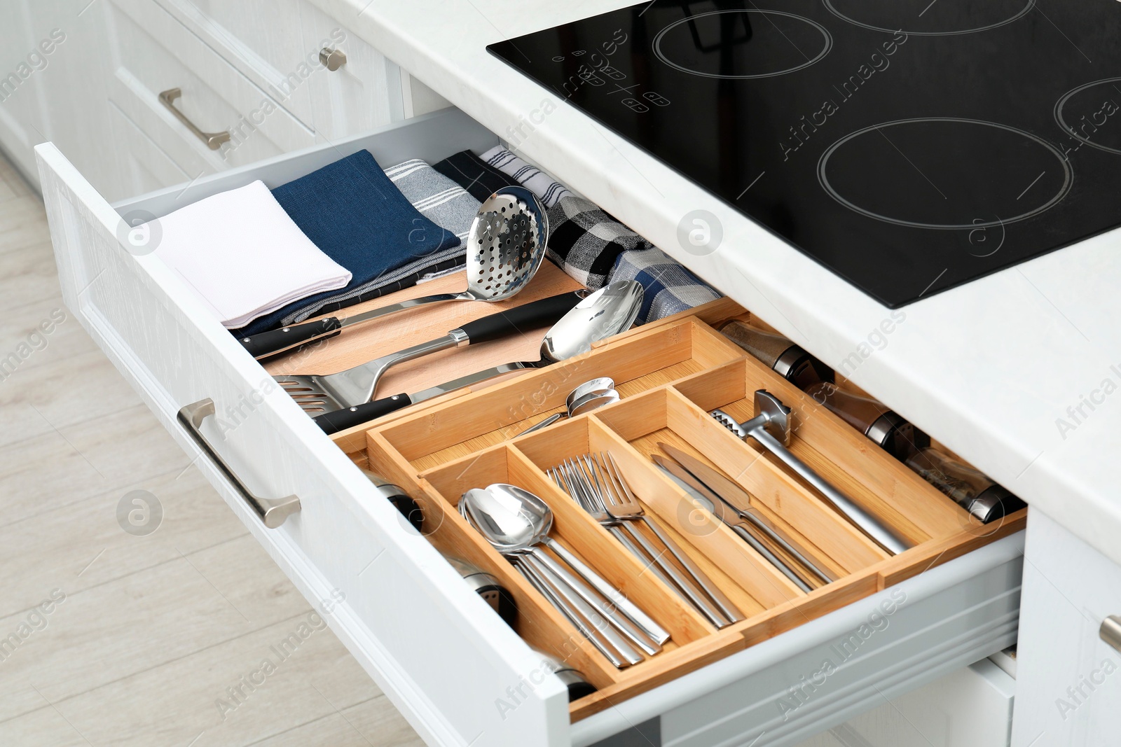 Photo of Box with cutlery in drawer, closeup. Kitchen utensils storage