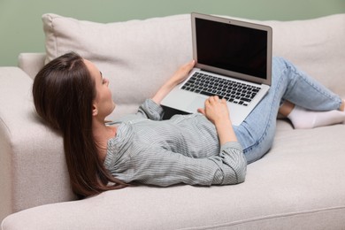 Photo of Woman with laptop lying on sofa at home