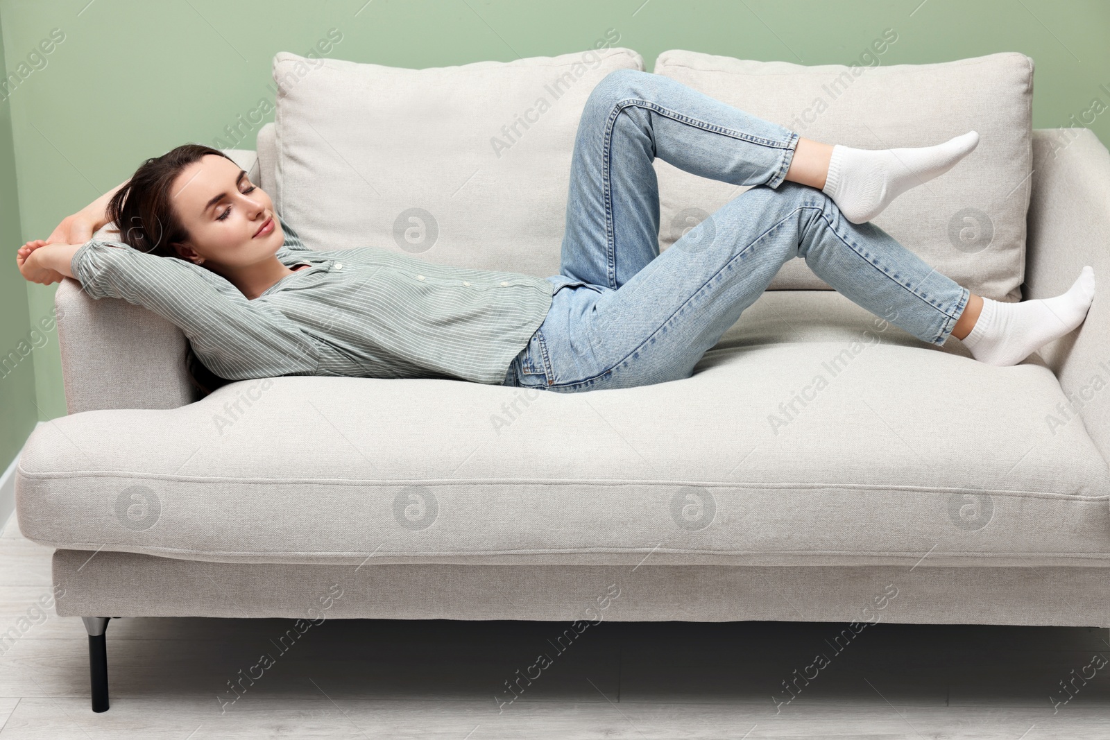 Photo of Beautiful woman relaxing on sofa at home