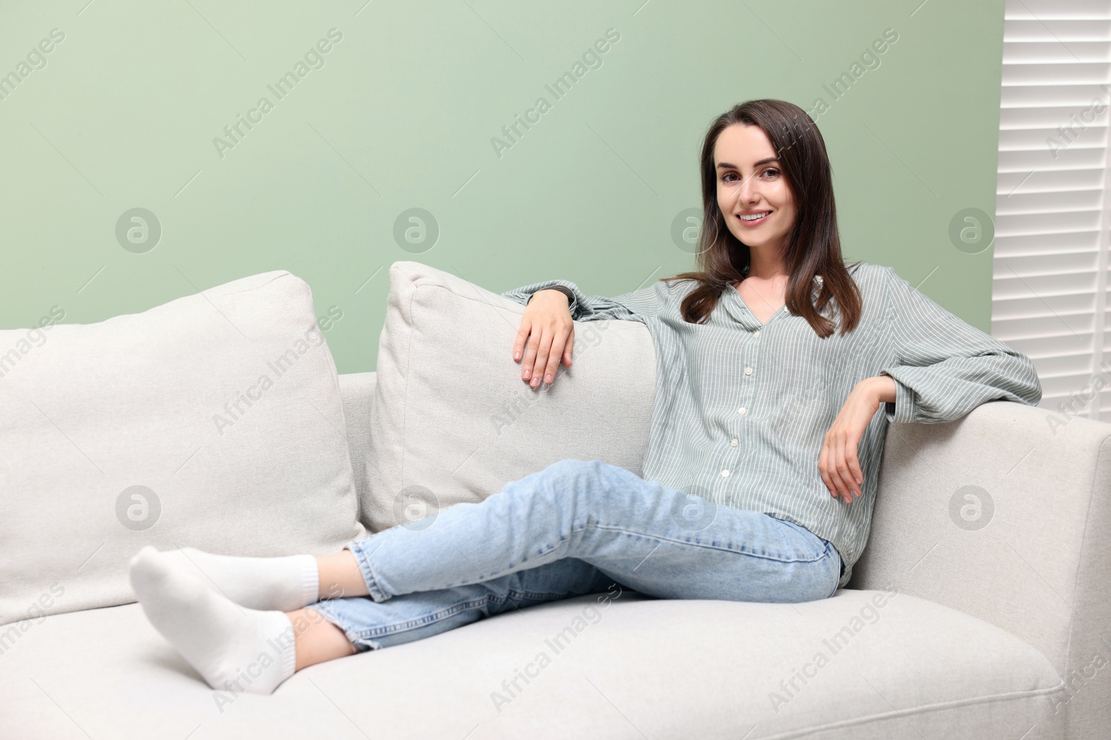 Photo of Smiling woman relaxing on sofa at home