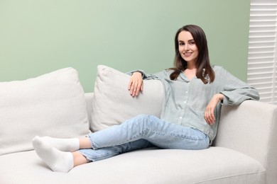 Smiling woman relaxing on sofa at home