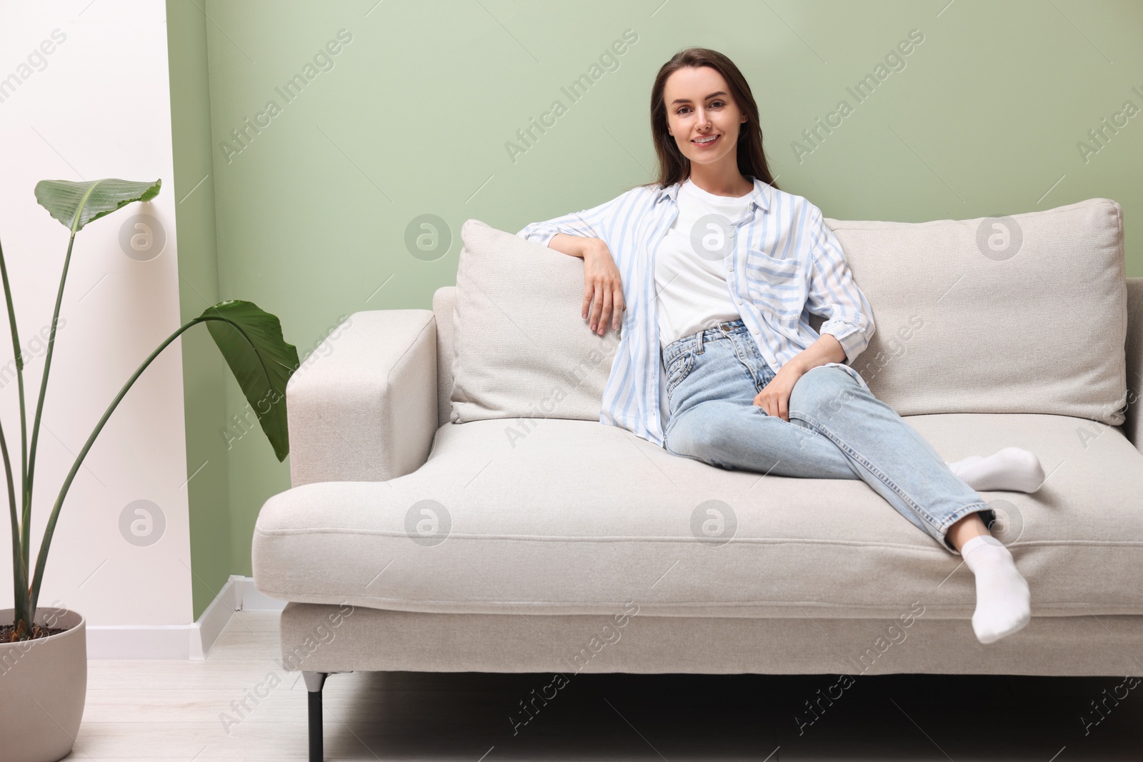 Photo of Smiling woman relaxing on sofa at home