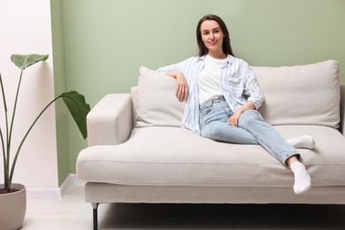 Smiling woman relaxing on sofa at home