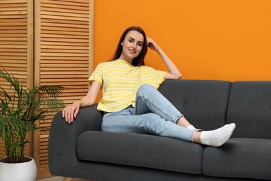 Photo of Smiling woman relaxing on sofa at home