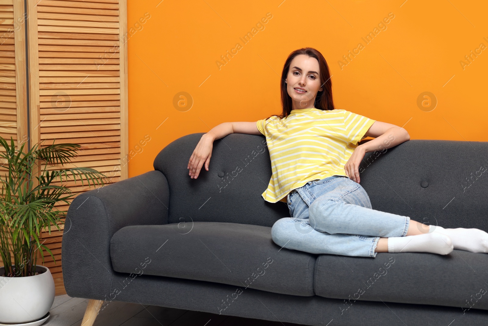 Photo of Smiling woman relaxing on sofa at home