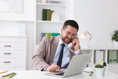 Smiling businessman working at table in office