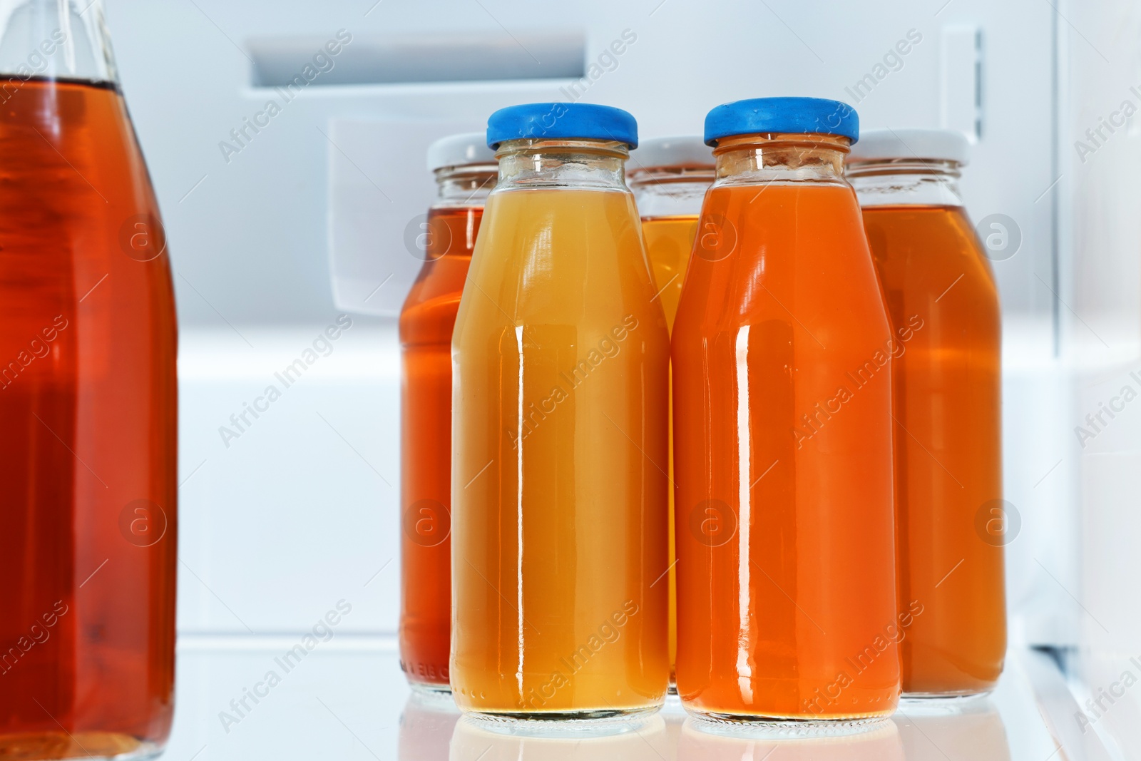 Photo of Many bottles of juice in refrigerator, closeup