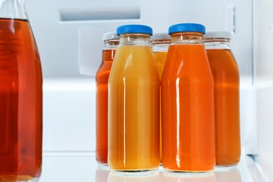 Photo of Many bottles of juice in refrigerator, closeup